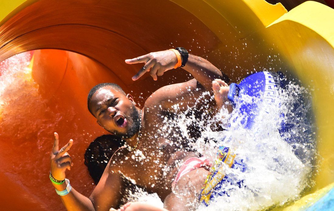A guest on a water slide, with the park's logo on the photo